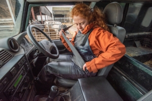 Female farmer fastening her seatbelt in a farm vehicle